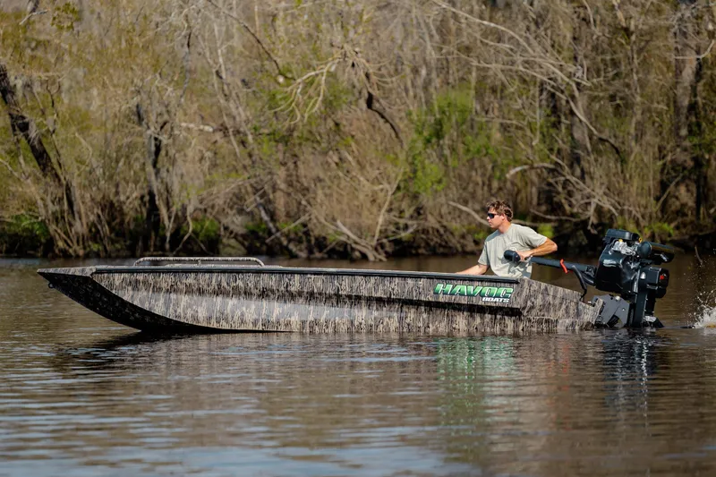 Slide: The Image of Man driving 2026 Havoc 1756 MSTC boat on a calm river. - 10