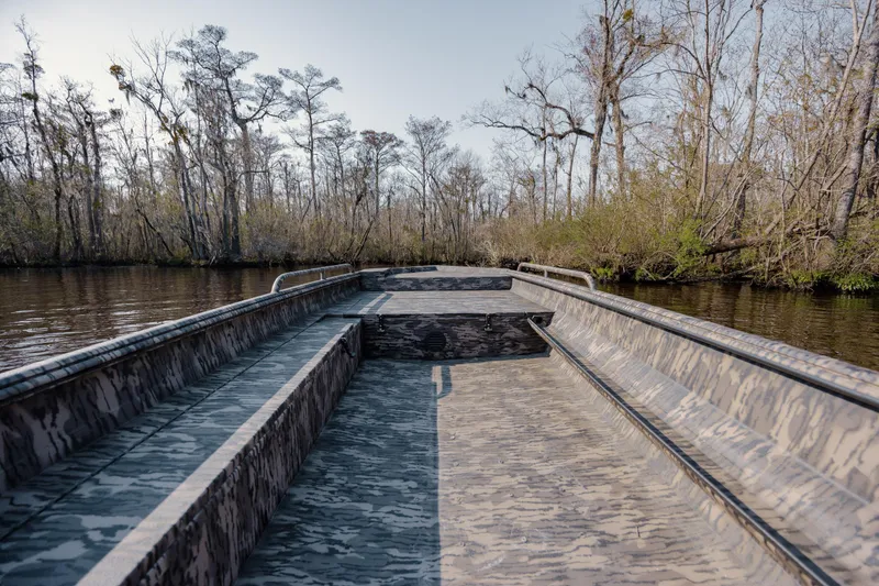 Slide: The Image of 2026 Havoc 1756 MSTC boat navigating a serene, tree-lined river. - 15