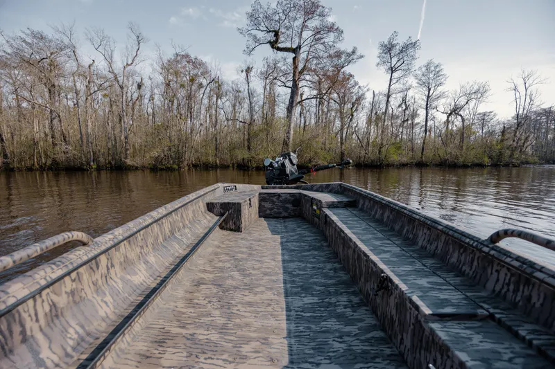 Slide: The Image of 2026 Havoc 1756 MSTC boat on a calm river, surrounded by trees. - 16