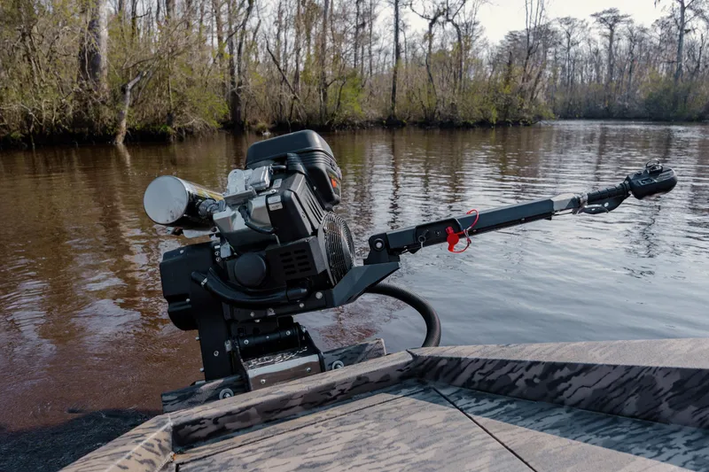 Slide: The Image of 2026 Havoc 1756 MSTC boat motor on a calm river, surrounded by trees. - 18