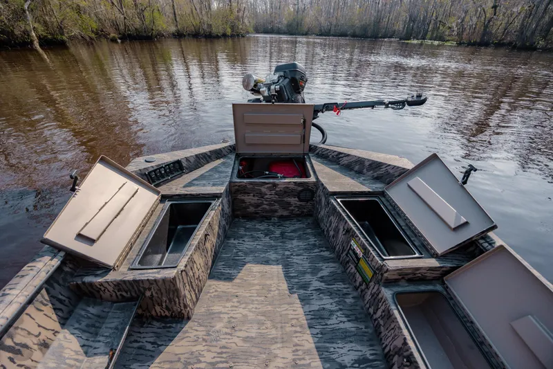Slide: The Image of 2026 Havoc 1756 MSTC boat with open storage compartments on a calm river. - 19