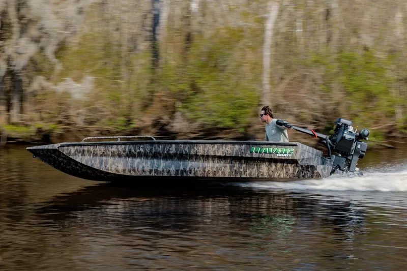 Slide: The Image of 2026 Havoc 1756 MSTC boat speeding on a river with a forest backdrop. - 2