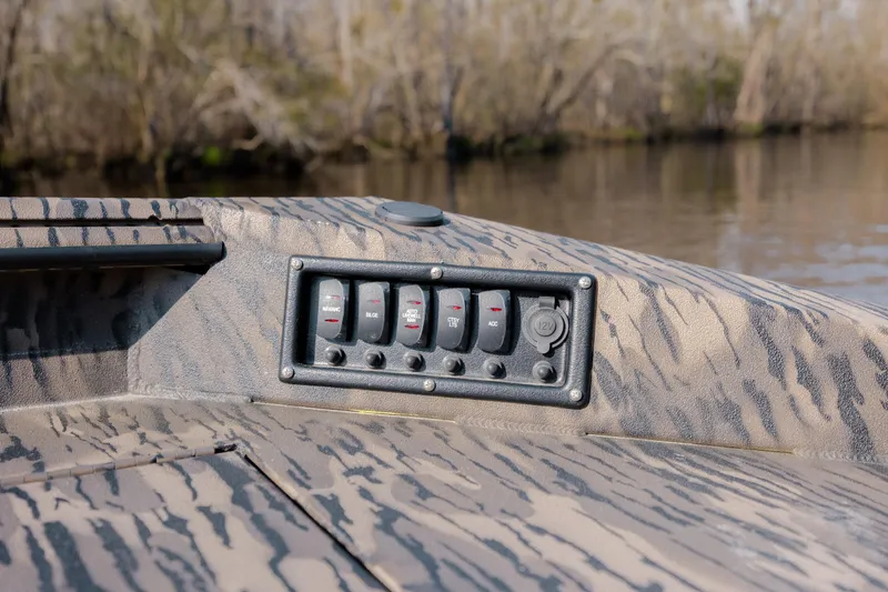 Slide: The Image of Control panel on a 2026 Havoc 1756 MSTC boat, featuring switches and a 12V outlet. - 25