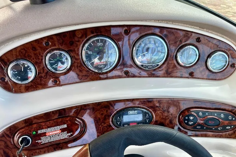 Slide: The Image of Dashboard of a 2004 Sea Ray 270 Sundeck boat with wood paneling and gauges. - 35