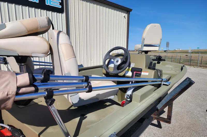 Slide: The Image of 2017 Tracker Grizzly 1648 SC boat with beige seats and steering wheel, parked outdoors. - 5
