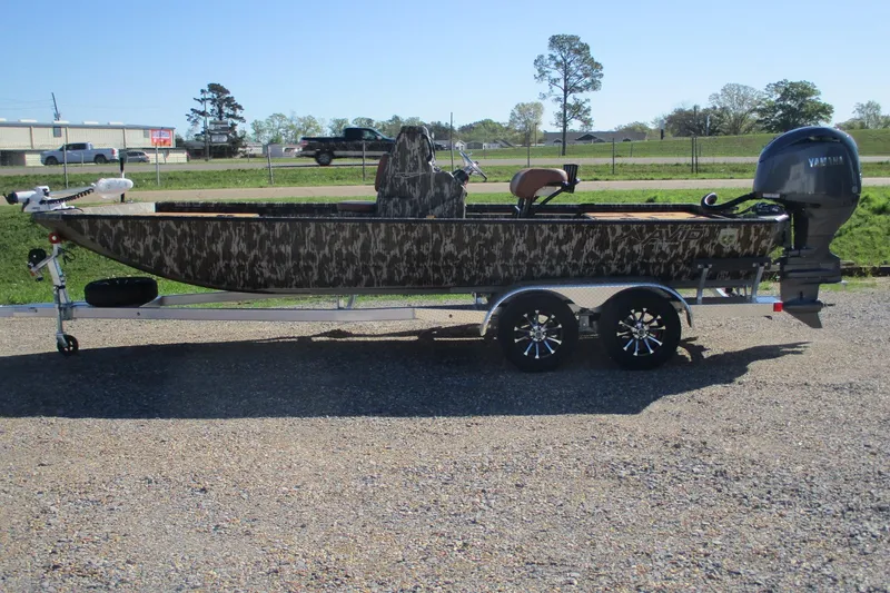 The Image of 2026 Avid 22 Rogue CC boat on trailer, camouflage design, parked outdoors. - 0