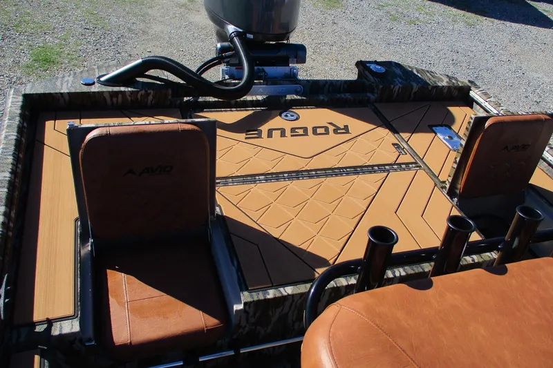 Slide: The Image of 2026 Avid 22 Rogue CC boat interior with tan seating and deck design. - 12