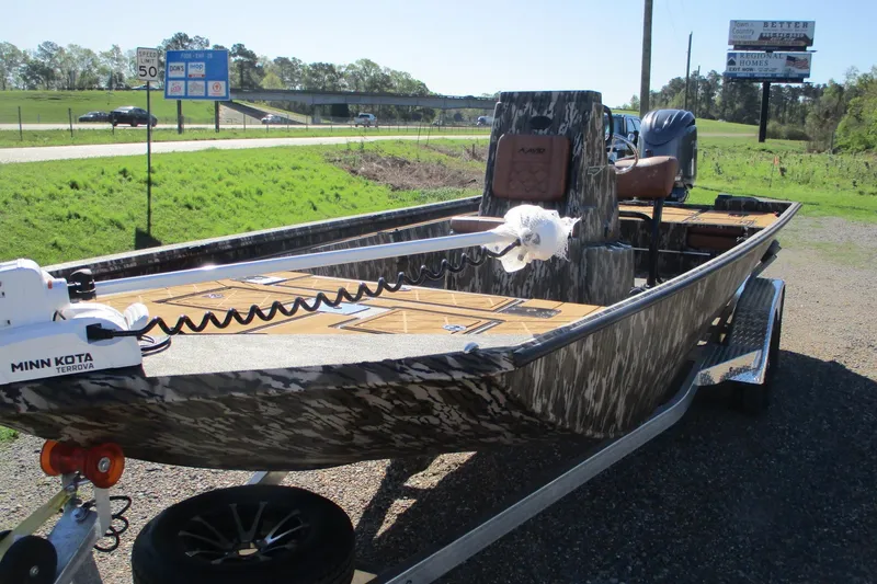 Slide: The Image of 2026 Avid 22 Rogue CC boat with Minn Kota motor on trailer, parked roadside. - 2