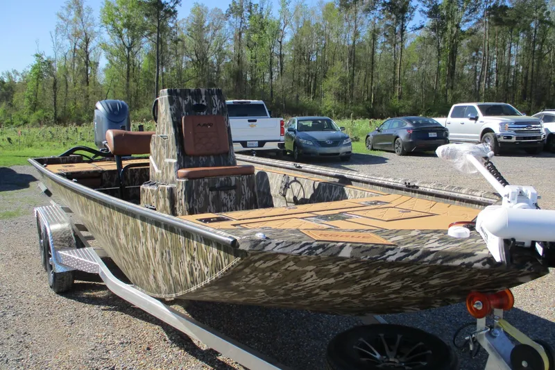 Slide: The Image of 2026 Avid 22 Rogue CC boat with camouflage design on a trailer in a parking lot. - 3