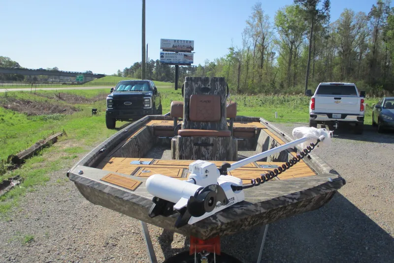 Slide: The Image of 2026 Avid 22 Rogue CC boat with camo design and trolling motor, parked outdoors. - 4
