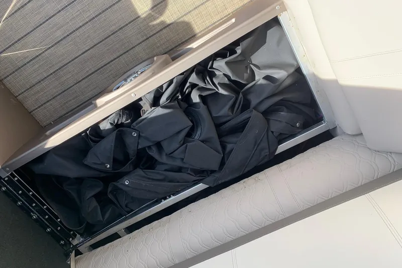 Slide: The Image of Storage compartment in 2024 Avalon Catalina Quad Lounge boat, containing black fabric. - 19