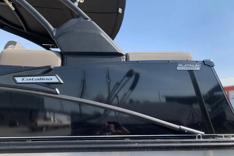 Slide: The Image of 2024 Avalon Catalina Quad Lounge boat, black exterior, Platinum Edition badge visible. - 3