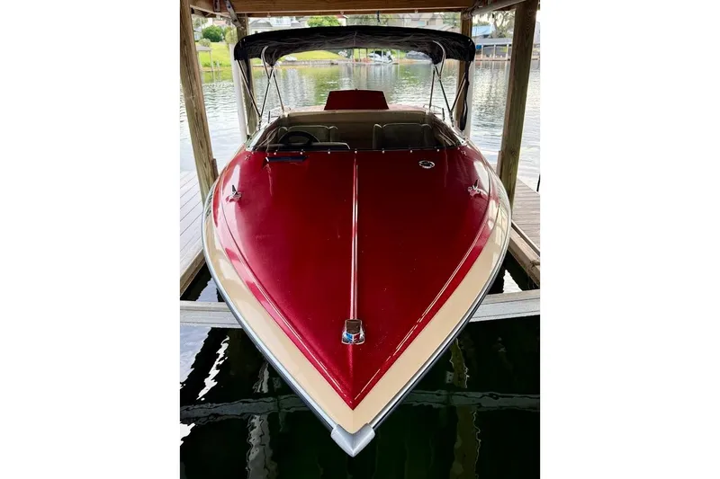 Slide: The Image of 1981 Glaston/Carlson C-512 boat with red and beige exterior, docked under a canopy. - 2