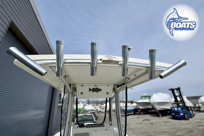 Slide: The Image of 2018 KenCraft Challenger 206 boat with rod holders and logo, parked outdoors. - 6