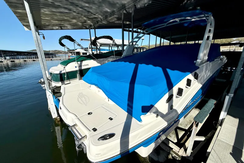 Slide: The Image of 2017 Chaparral 246 SSi boat docked with blue cover under a marina shelter. - 16