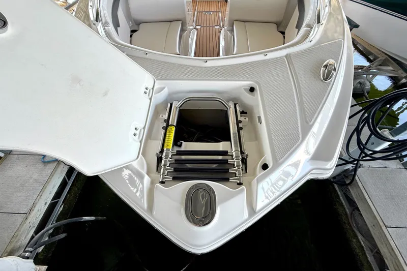 Slide: The Image of 2017 Chaparral 246 SSi boat with open storage compartment and visible ladder. - 27