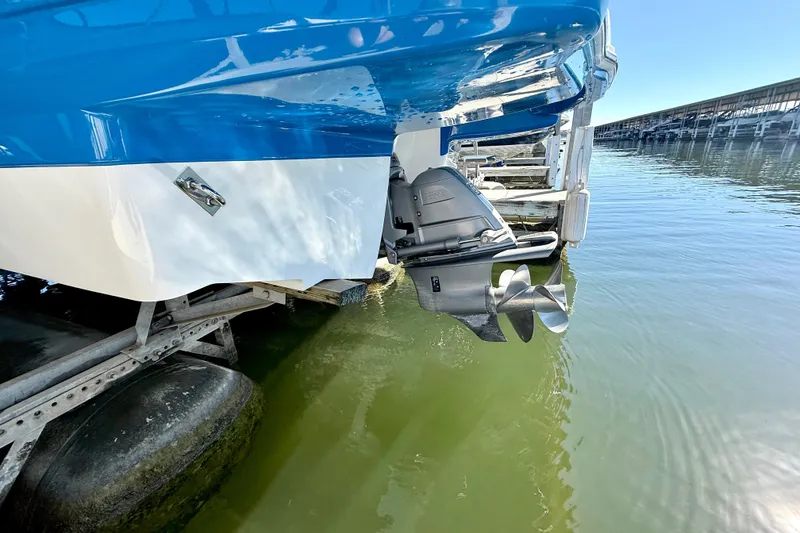 Slide: The Image of 2017 Chaparral 246 SSi boat stern with outboard motor in marina setting. - 29
