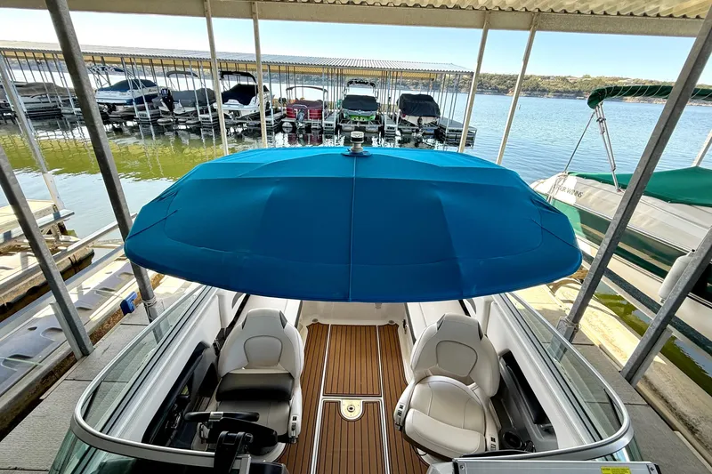 Slide: The Image of 2017 Chaparral 246 SSi boat with blue canopy docked at marina. - 33