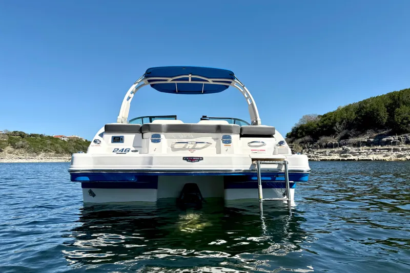 Slide: The Image of 2017 Chaparral 246 SSi boat on water with blue canopy and swim ladder. - 4