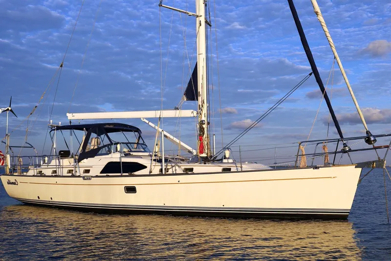 The Image of 2009 Passport Vista 515 Center Cockpit sailboat on calm water under blue sky. - 0
