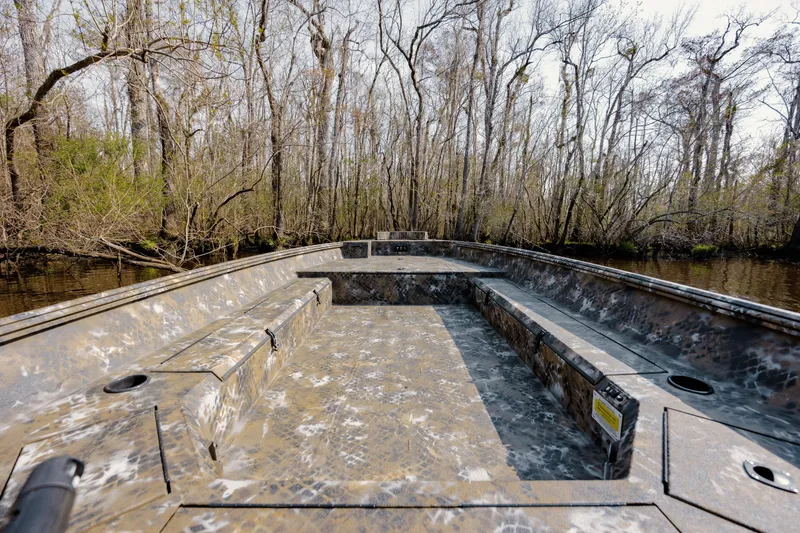 Slide: The Image of 2026 Excel 183 Tomahawk boat in wooded swamp, showcasing spacious interior and camouflage design. - 17