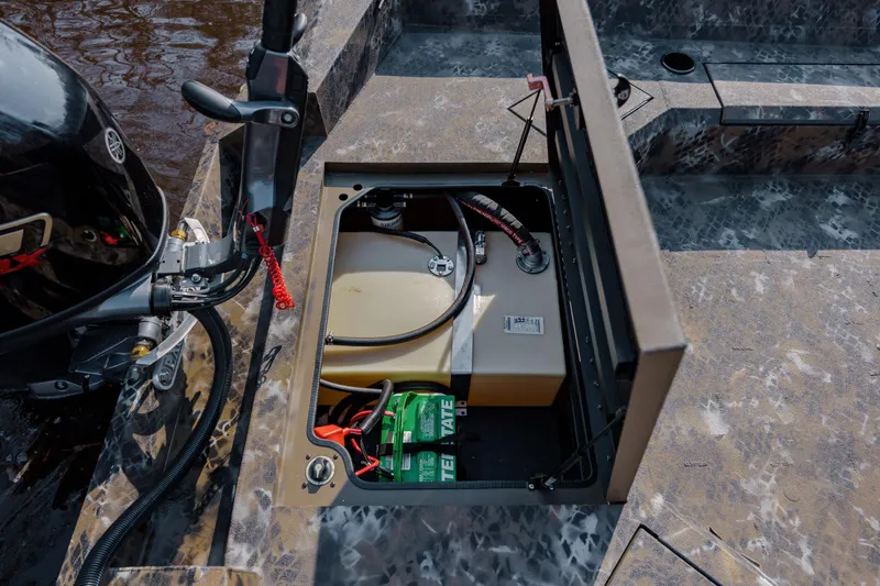 Slide: The Image of Open storage compartment in 2026 Excel 183 Tomahawk boat, showing battery and fuel tank. - 30