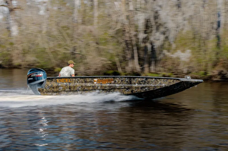 Slide: The Image of 2026 Excel 183 Tomahawk boat speeding on a river with forest background. - 4