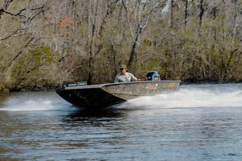 Slide: The Image of Man driving 2026 Excel 183 Tomahawk boat on a river, surrounded by trees. - 6