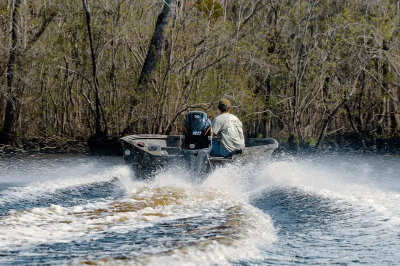 Slide: The Image of Man driving 2026 Excel 183 Tomahawk boat on a river, surrounded by trees. - 9