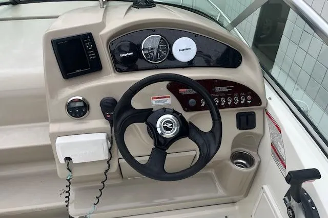 Slide: The Image of 2008 Sea Ray 240 Sundancer helm with steering wheel and navigation instruments. - 10