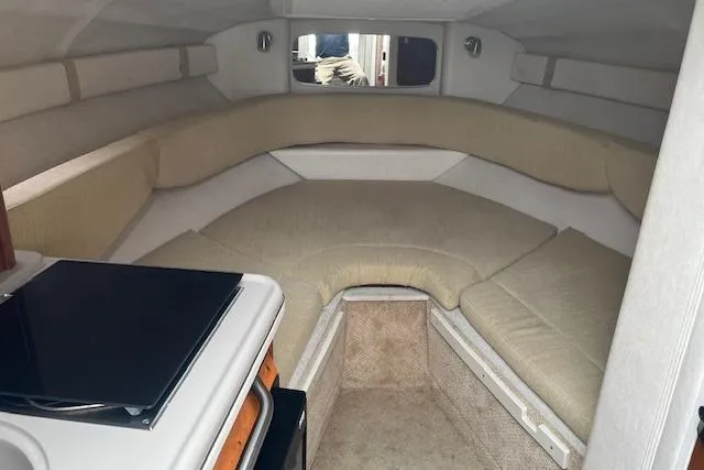 Slide: The Image of 2008 Sea Ray 240 Sundancer cabin interior with beige seating and compact kitchenette. - 12