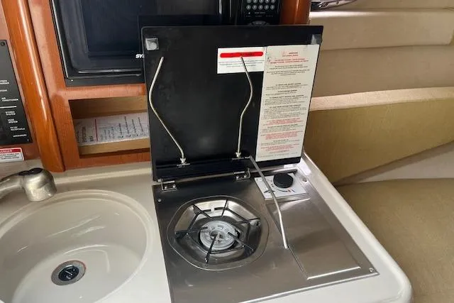 Slide: The Image of 2008 Sea Ray 240 Sundancer interior with stove and sink in cabin. - 18