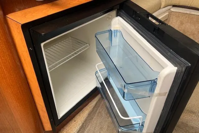 Slide: The Image of Open mini fridge inside 2008 Sea Ray 240 Sundancer boat cabin. - 19