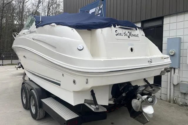 Slide: The Image of 2008 Sea Ray 240 Sundancer boat on trailer, covered, parked outdoors. - 2