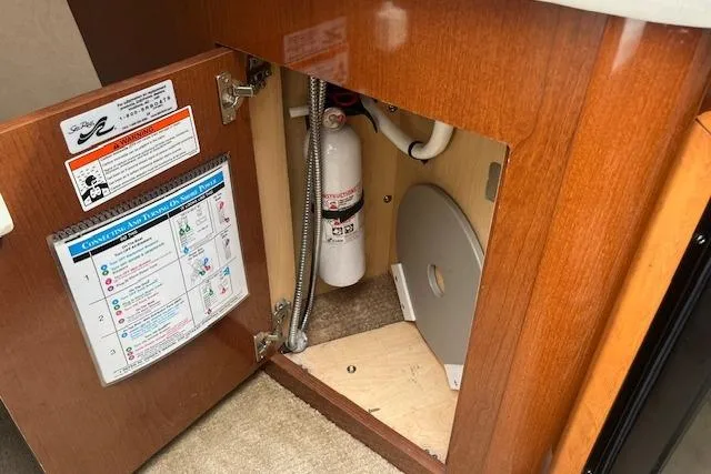 Slide: The Image of 2008 Sea Ray 240 Sundancer interior cabinet with fire extinguisher and safety instructions. - 20