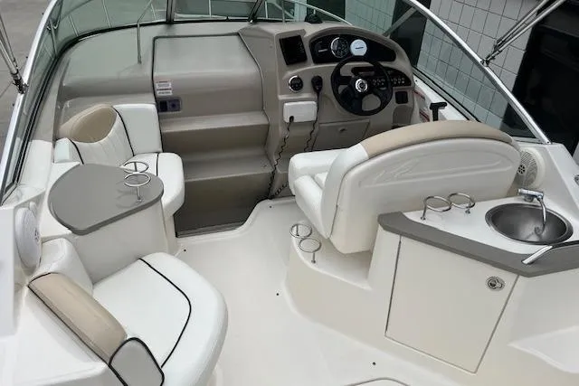 Slide: The Image of 2008 Sea Ray 240 Sundancer boat interior with helm, seating, and sink. - 6