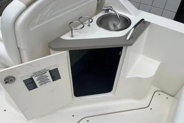 Slide: The Image of 2008 Sea Ray 240 Sundancer boat interior with sink and storage compartment. - 8