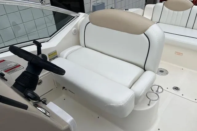 Slide: The Image of 2008 Sea Ray 240 Sundancer cockpit with white seating and steering wheel. - 9
