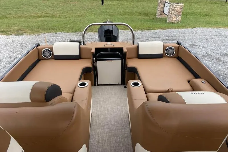 Slide: The Image of 2024 Avalon Catalina 2585 RL boat interior with tan seating and cup holders. - 10