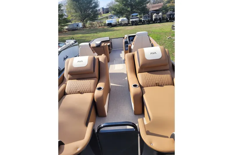 Slide: The Image of 2024 Avalon Catalina 2585 RL boat with luxurious tan seating and cup holders. - 11