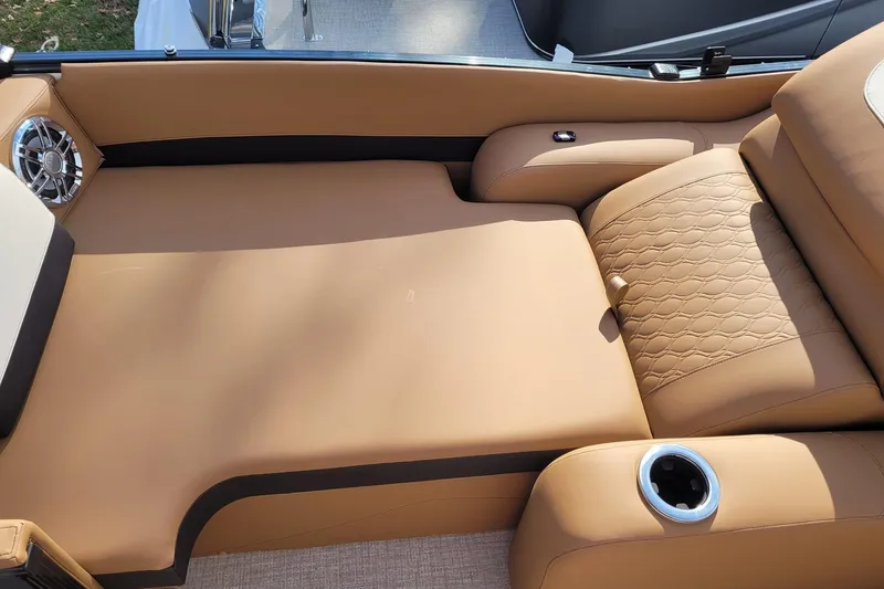 Slide: The Image of Luxurious tan seating on 2024 Avalon Catalina 2585 RL boat with cup holder and speaker. - 12