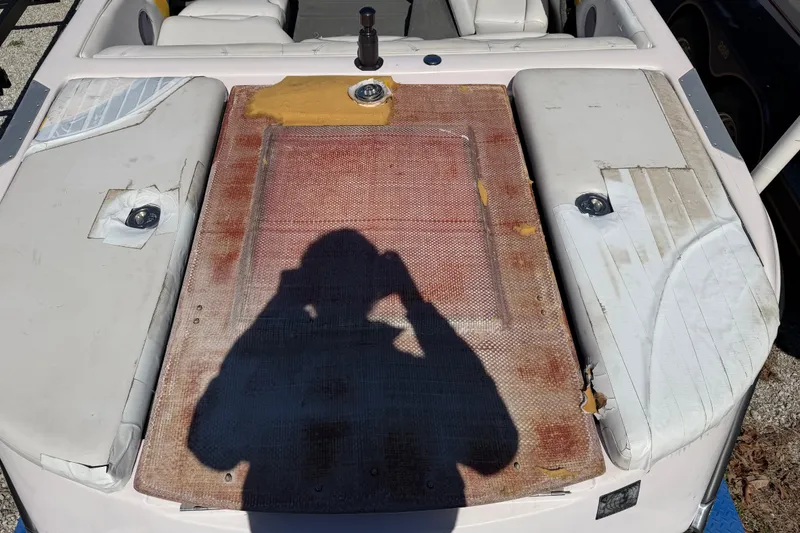 Slide: The Image of 2004 Nautique Super Air Nautique 210 boat interior with worn upholstery and visible shadow. - 15
