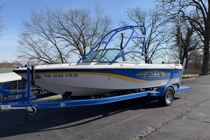 Slide: The Image of 2004 Nautique Super Air Nautique 210 boat on trailer, parked outdoors. - 2