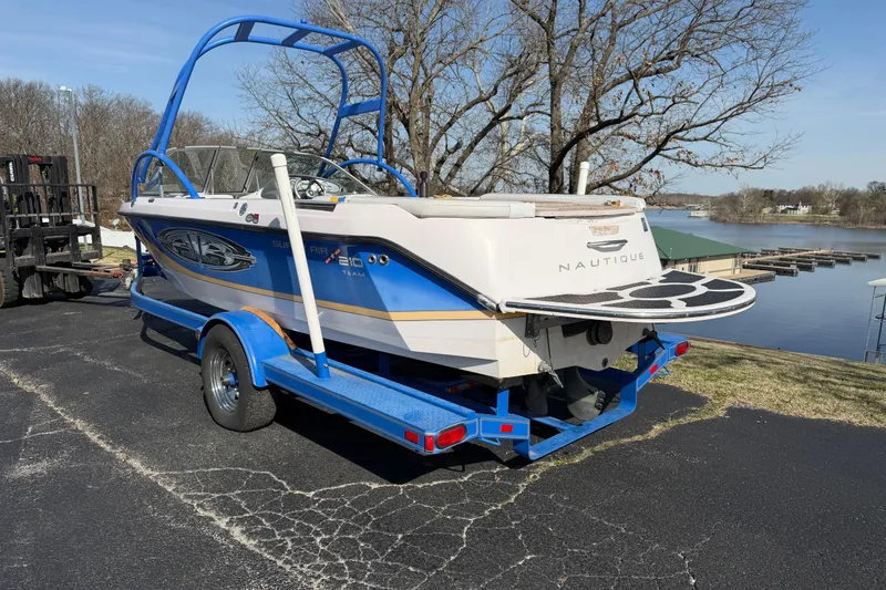Slide: The Image of 2004 Nautique Super Air Nautique 210 boat on trailer by a lake. - 3