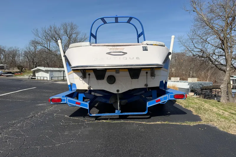 Slide: The Image of 2004 Nautique Super Air Nautique 210 boat on a blue trailer, parked outdoors. - 4