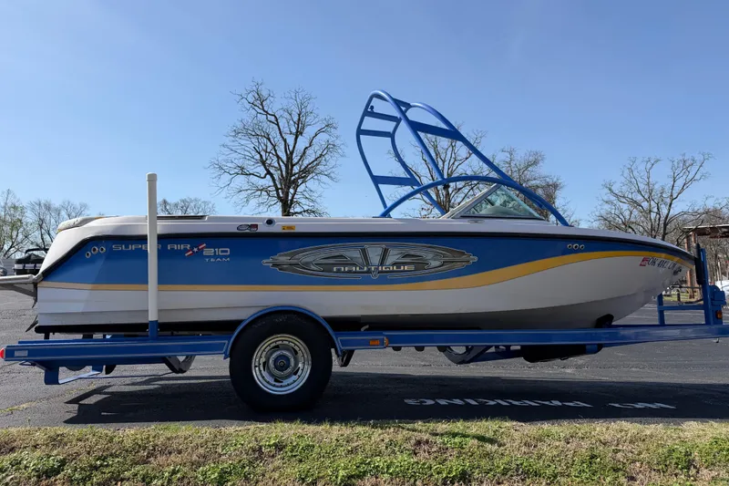Slide: The Image of 2004 Nautique Super Air Nautique 210 boat on trailer, blue and white design. - 6