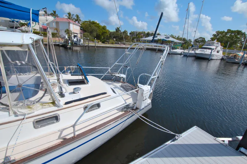 Slide: The Image of 1987 Morgan 43 CC sailboat docked in a serene marina setting. - 10