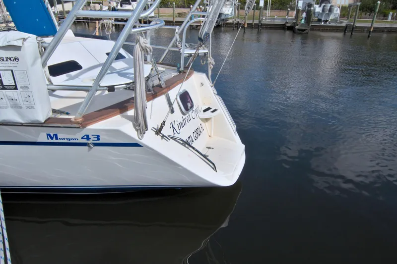 Slide: The Image of 1987 Morgan 43 CC sailboat docked in marina, featuring sleek design and white hull. - 11