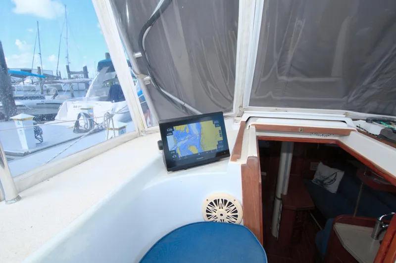 Slide: The Image of Interior view of 1987 Morgan 43 CC sailboat with navigation system and marina backdrop. - 27