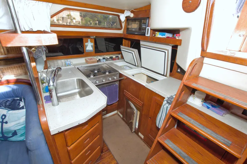 Slide: The Image of 1987 Morgan 43 CC yacht interior kitchen with wooden cabinetry and modern appliances. - 34